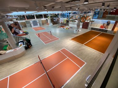 Vue intérieure d'un espace de sport avec plusieurs terrains de tennis en salle.