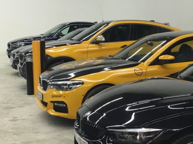 Série de voitures BMW de différentes couleurs alignées dans un garage.